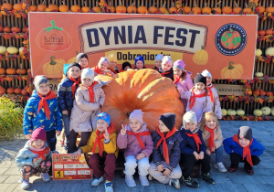 Dzieci pozują do zdjęcia przy ogromnej dyni