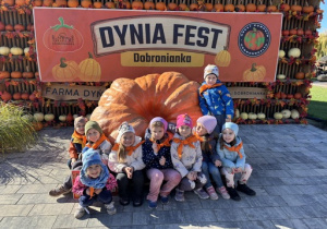 Dzieci stoją przy ogromnej dyni