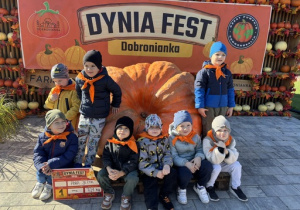 Dzieci stoją przy ogromnej dyni