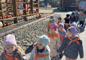 Dzieci spacerują i oglądają jesienne aranżacje
