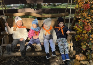 Dziewczynki i chłopiec huśtają się na huśtawce