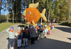 Dzieci stoją na tle ogromnej ryby z dyń