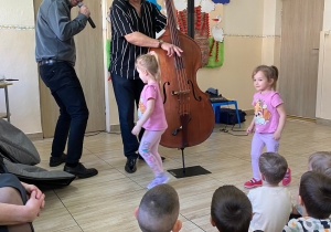 Dwie dziewczynki poruszają się w rytm granej na wiolonczeli melodii.
