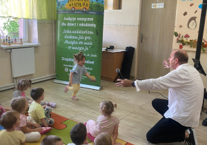 Dziewczynka radośnie interpretuje allegro i wesoło biegnie w kierunku prowadzącego.