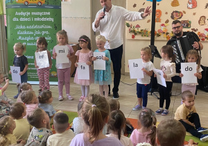 Ośmioro dzieci prezentuję napisy dźwięków gamy.