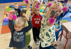 Chłopcy unoszą do góry małe różowe breloczki dla dziewczynek