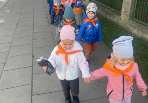Dzieci parami idą w kierunku pobliskiego osiedla.