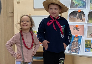 Dziewczynka i chłopiec prezentują się w akcesoriach do muzyki granej na klarnecie.