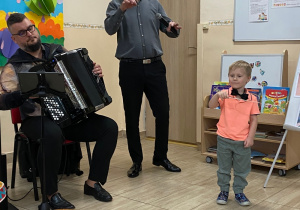 Chłopiec prezentuje batutę i dyryguje w takt granego utworu.