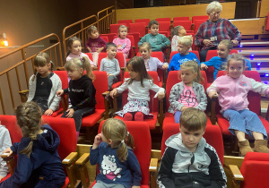Przedszkolaki z grupy "Kangurki" już siedzą w fotelach w sali kinowej.