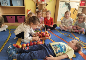 Dzieci podczas zabawy ,,Wędrujące jabłko”.