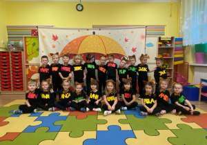 Wszystkie dzieci wspólnie prezentują się na tle "jesiennego parasola".