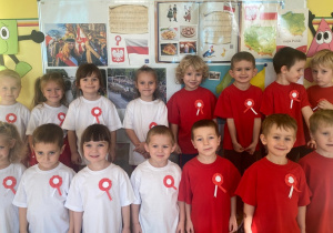 Wspólne zdjęcie dzieci na tle symboli narodowych