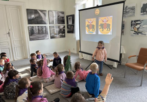 Dzieci słuchają ciekawostek o ekspozycji znajdującej się w muzeum.