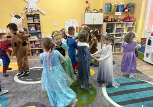 Dzieci w przebraniach tańczą na dywanie