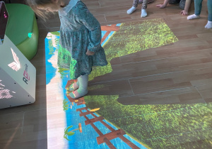 Dziewczynka zbiera owoce na "Owocowej ścieżce".