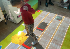 Dziewczynka zbija jadące samochody.