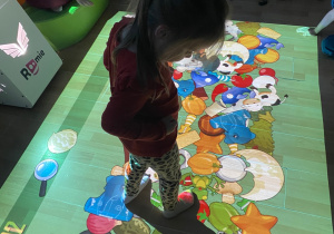 Dziewczynka wyszukuje wśród wielu warzyw i owoców wskazany.