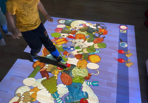 Chłopiec wyszukuje wśród wielu warzyw i owoców wskazany.