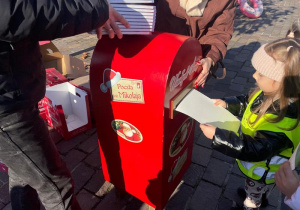 Dziecko rzuca list do skrzynki