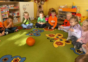 Dzieci turlają dynię.