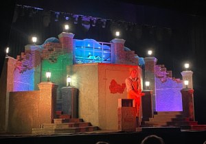 Jurek - bohater baśni na tle kolorowej scenografii.