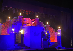 "Niewidomy" i Irmina na tle scenografii - fragment miasta.