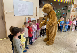 Miś Tedi wita się z dziećmi.