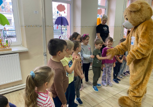 Miś Tedi wita się z dziećmi.