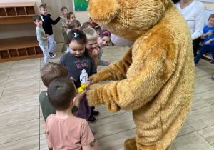 Zabawa w kole-dzieci szybko podają sobie "cukierka", tak by nie przechwycił go miś.