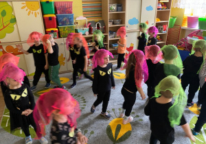 Dzieci biegają z neonowymi chustkami na głowie, udając duszki.