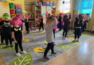 Dzieci biegają z neonowymi chustkami na głowie, udając duszki.