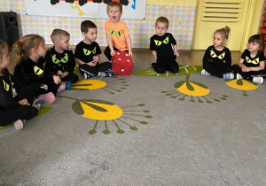 Dzieci rzucają dużą kostką.