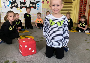 Dzieci rzucają dużą kostką.