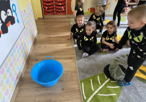 "Studnia życzeń" - chłopiec wrzuca grosik do miski z wodą.