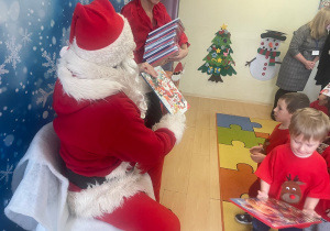 "Mikołaj" wręcza chłopcu upominek.