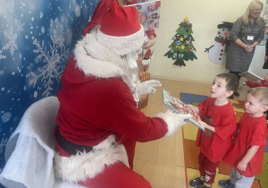 "Mikołaj" wręcza chłopcu upominek.