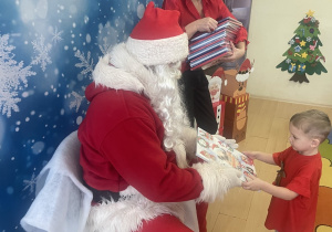 "Mikołaj" wręcza chłopcu upominek.