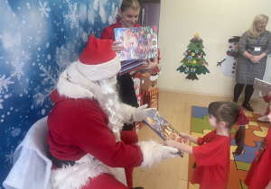 "Mikołaj" wręcza dziewczynce upominek.