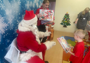 "Mikołaj" wręcza chłopcu upominek.