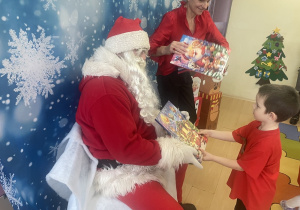 "Mikołaj" wręcza chłopcu upominek.