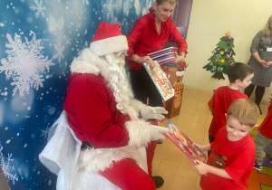 "Mikołaj" wręcza chłopcu upominek.