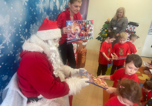 "Mikołaj" wręcza chłopcu upominek.