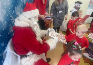"Mikołaj" wręcza chłopcu upominek.