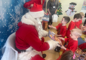 "Mikołaj" wręcza chłopcu upominek.