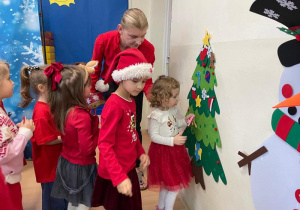 Dzieci ozdabiają choinkę
