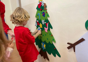 Dzieci ozdabiają choinkę
