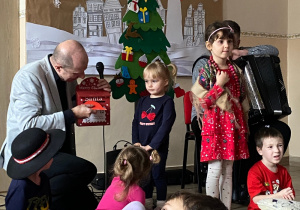 Dzieci z góralskimi akcesoriami śpiewają i tańczą.