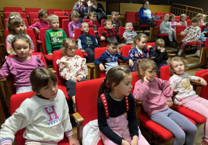 Dzieci siedzące na widowni w oczekiwaniu na rozpoczęcie projekcji filmu.