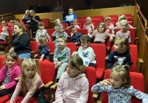 Dzieci siedzące na widowni w oczekiwaniu na rozpoczęcie projekcji filmu.